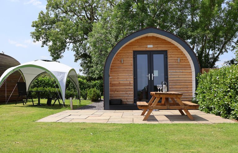 An outdoor area with a pod and seating at Honeypot Hideaways - Manuka