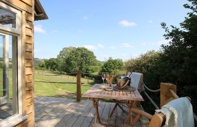An outdoor seating area with a table and chairs at Squirrel's Drey Chapel Lawn near Clun