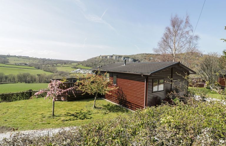 A cabin with a deck in an outdoor area at Alpine Lodge in Rhyd-y-Foel near Abergele