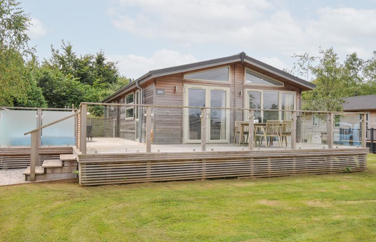An outdoor area with a wooden cabin and deck at 3 Meadow Retreat in Liskeard