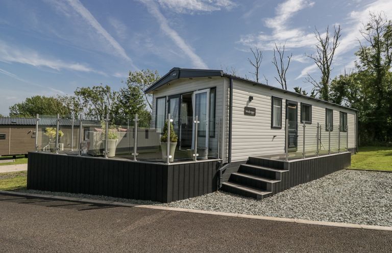 A caravan with steps and glass railing at Grasmoor View Lodge