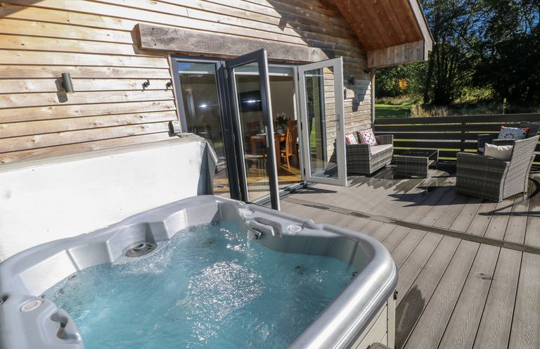 An outdoor area with a hot tub and seating at Dwrgi Llanybydder
