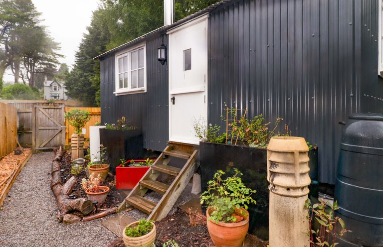 An exterior view of a hut with steps and planters at Shepherd's Hut in Pentyrch