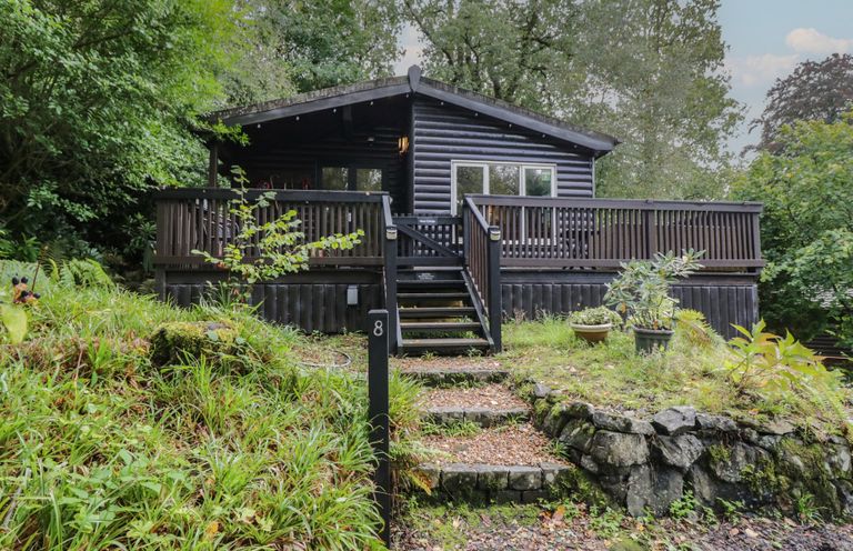 A cabin with steps and a deck at Moon Cottage in White Cross Bay Holiday Park near Troutbeck Bridge