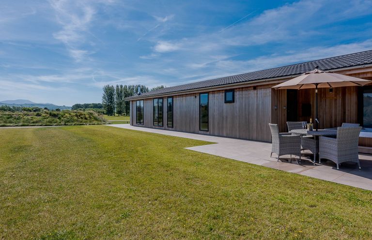 A building with seating area and grass at Wordsworth in Wigton