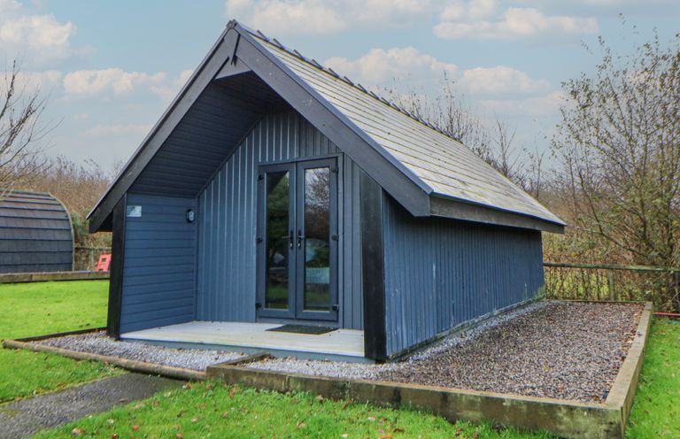 A cabin with a gravel path and grass area at Garden lodge 3 Swansea