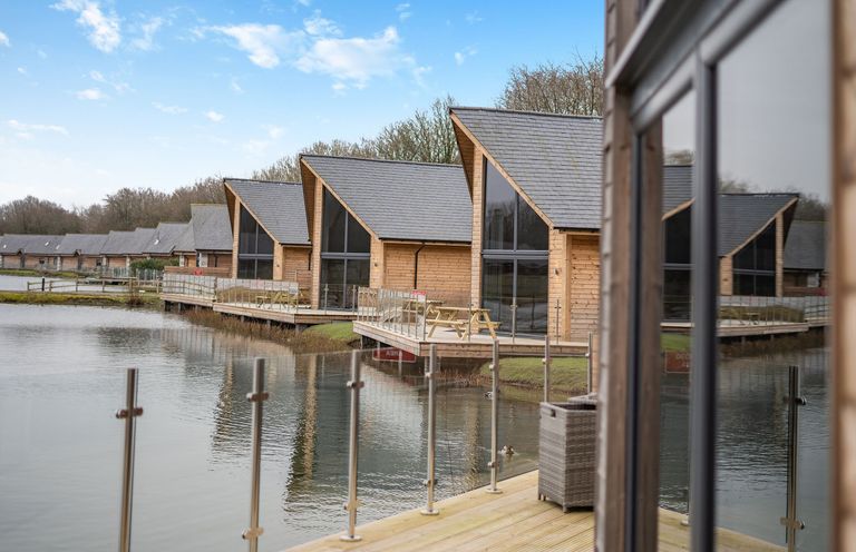Cabins by a lake with deck and railings at Tranquillity 3 Warton near Carnforth