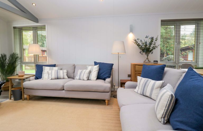 A living room with a sofa and cushions at 5 Waterside Wood Troutbeck Bridge