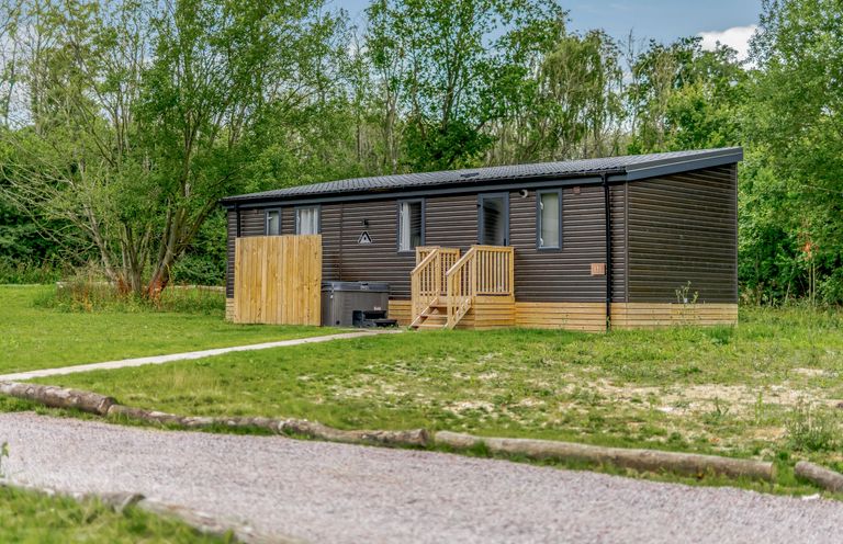 A cabin with wooden steps and windows at Horncastle Plus in Louth