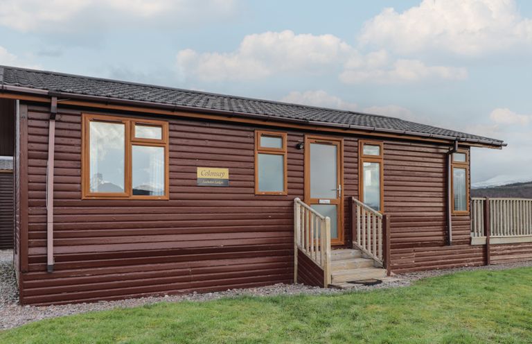 A log cabin with windows and a sign at Colonsay