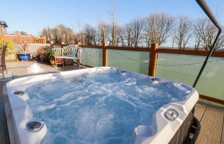 A hot tub surrounded by seating and plants at FW4 (Fairways 4) Doublebois near Dobwalls