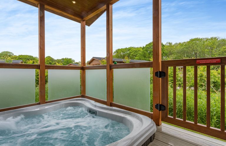 A hot tub surrounded by wooden railing in an outdoor area at The Chesterton in Kings Cliffe
