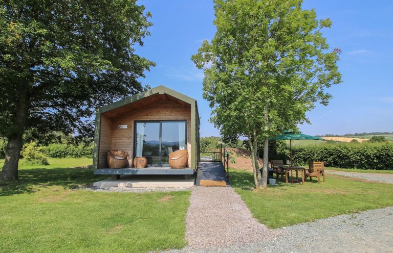 A cabin with outdoor seating area at Leafy Oaks Cabin in Munslow