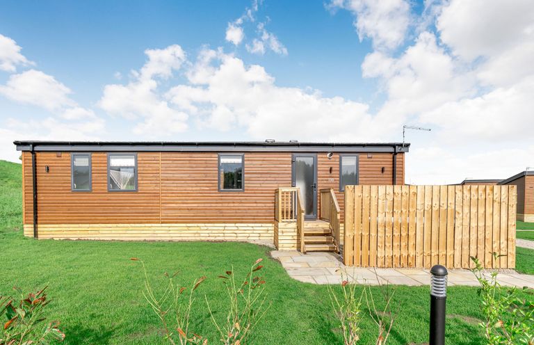 A wooden building with steps and a fence at Kinder Spa (Pet) Carlton Miniott near Thirsk