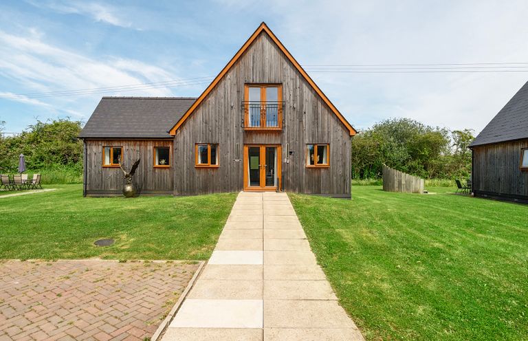 A house with wooden exterior and pathway at Charcoal Lodge in Brigg