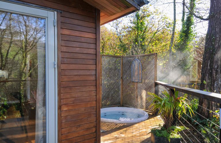 An outdoor area with a jacuzzi and wooden deck at 6 Stonerush Valley Looe