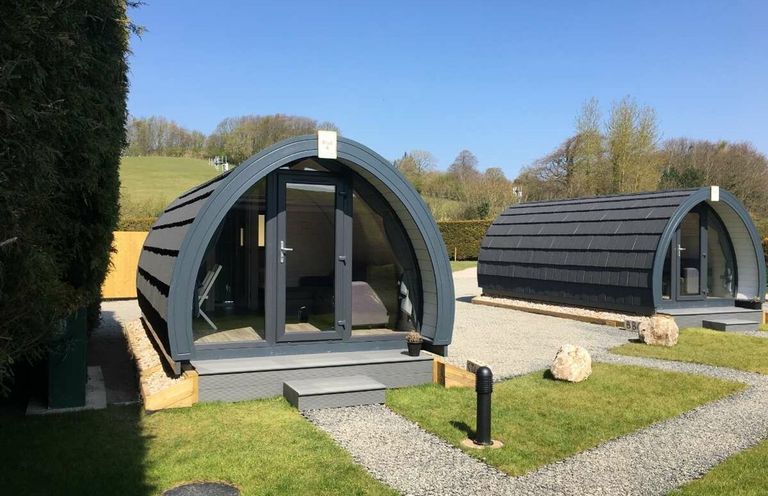 Two cabins with a gravel path and grass area at Pod 4 (No Pets) in Carnforth