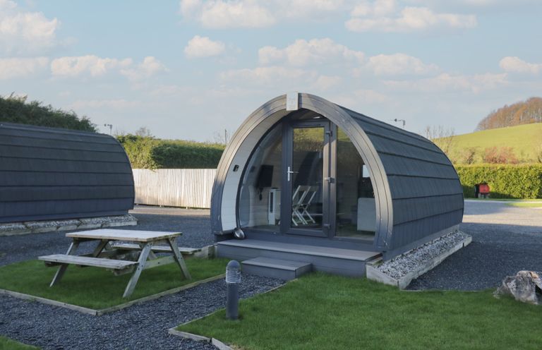 A pod with a picnic table and grass area at Pod 5 (Pet Friendly) Tewitfield