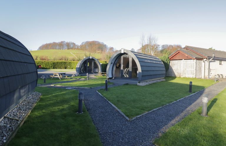 An outdoor area with glamping pods and a picnic table at Pod 7 (Pet Friendly) Tewitfield
