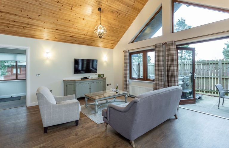 A living room with a sofa and coffee table at Byron Premier Spa (Pet) in Dundee