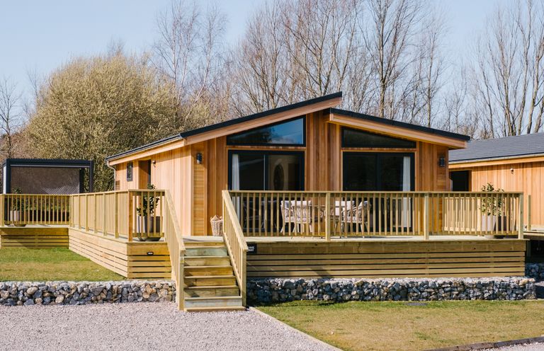 A cabin with a wooden deck and outdoor seating at Moonlight Spa Luxury in Waltham