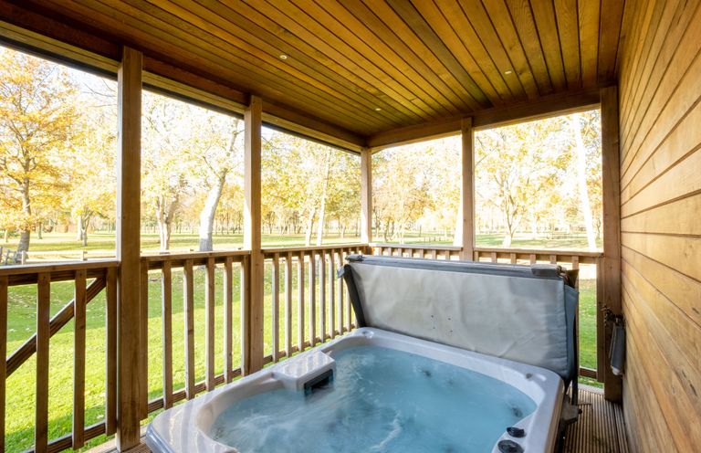 An outdoor area with a hot tub on a wooden deck at Wentworth in Waltham