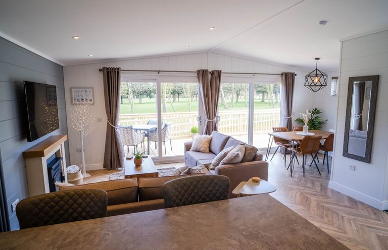 A living room with a sofa and dining area at Imperial View in Waltham