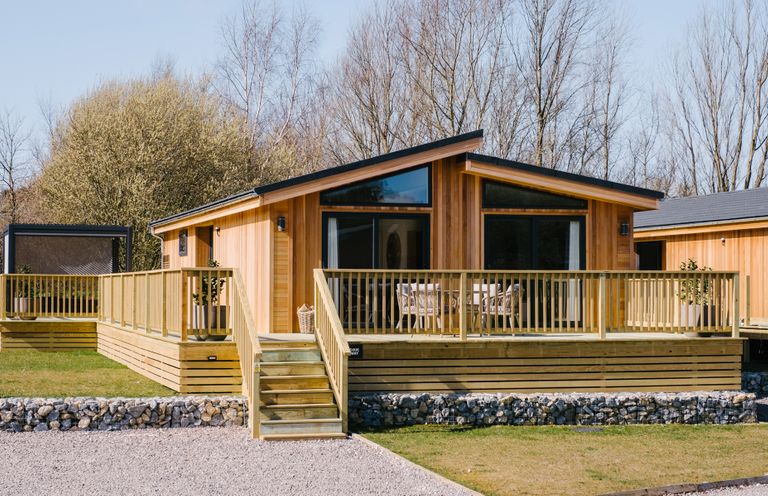 A wooden cabin with a deck and steps at The Luxury Hideaway in Waltham