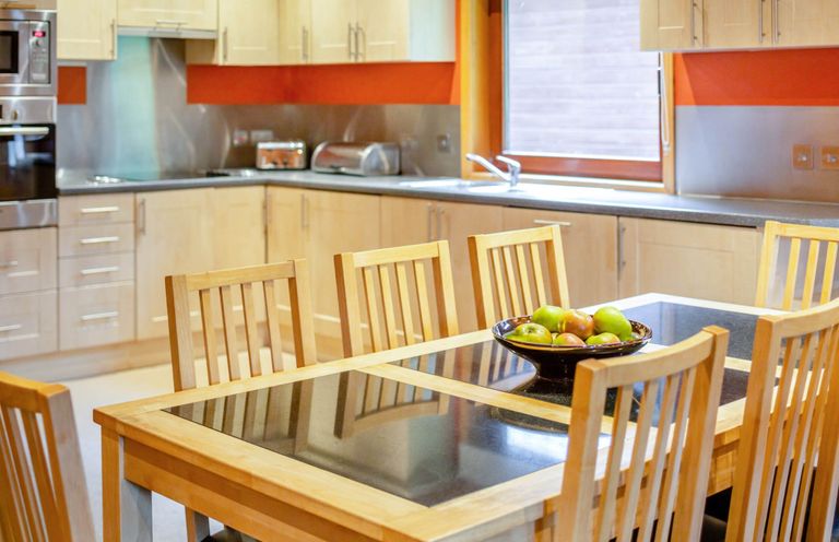 A kitchen with a dining table and chairs at Woodland Lodge Spa in Praze-An-Beeble