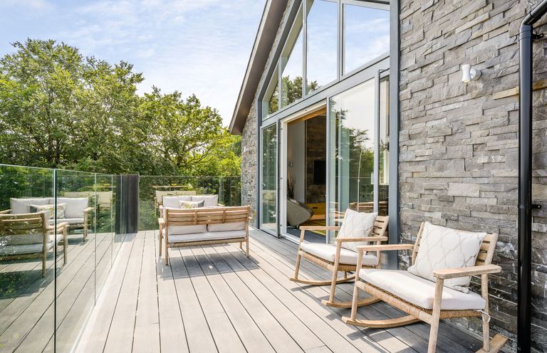 An outdoor deck with rocking chairs and a sofa at The View in Laugharne