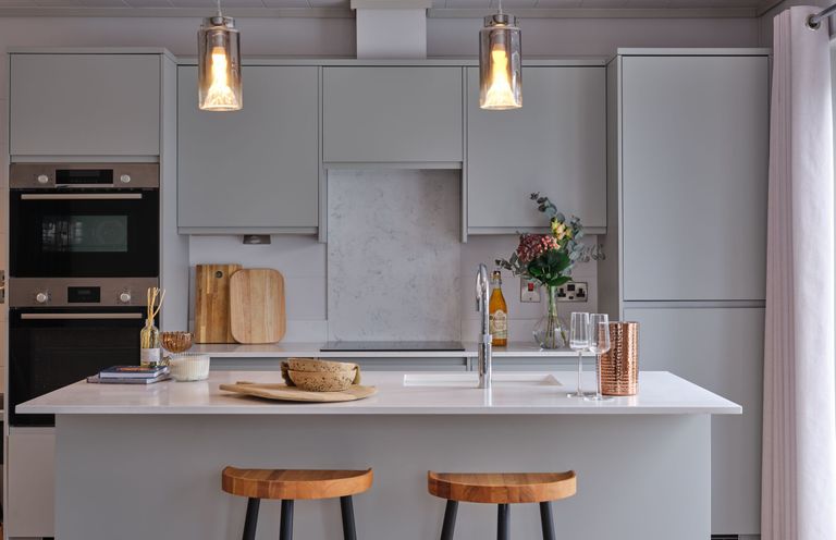 A kitchen with an island and bar stools at Epic Spa (Pet) in Laugharne
