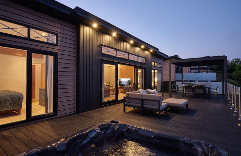 A deck with a hot tub and outdoor seating at Canto Spa in Laugharne