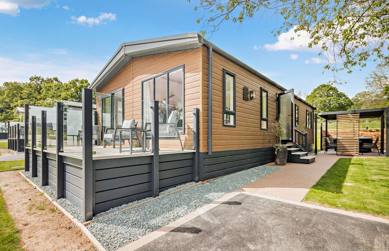 A house with a deck and chairs at Saron 2.0 Spa Pet in Llandyrnog