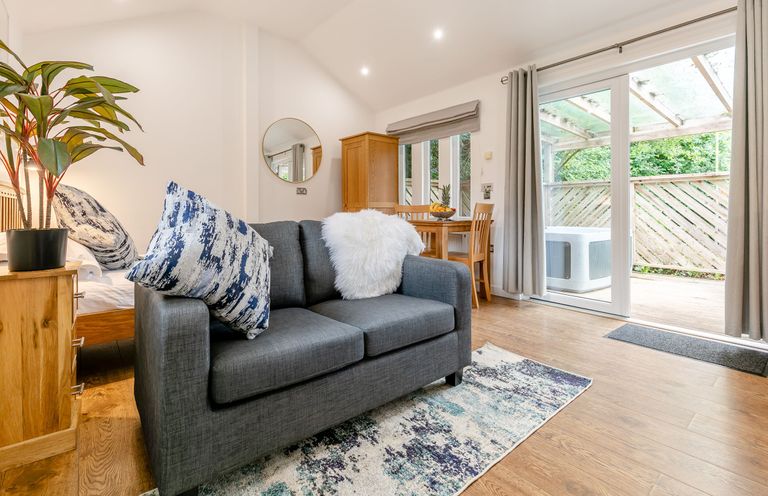 A living room with a sofa and dining table at Droskyn Spa Pet Perranporth