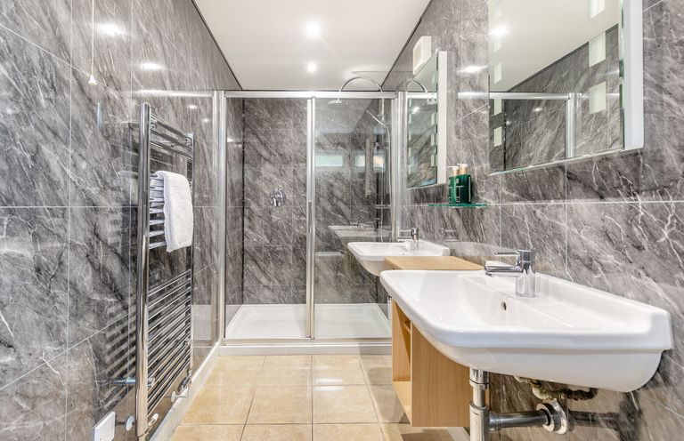 A bathroom with sinks and a shower at Tremewan Spa Pet Perranporth