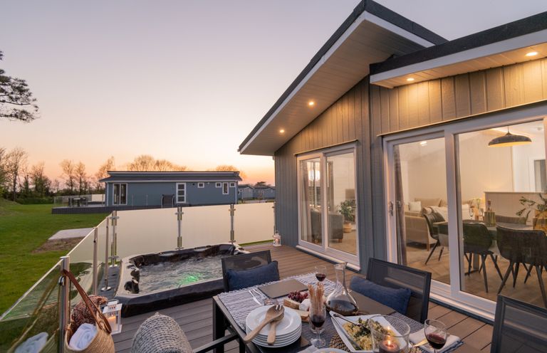 An outdoor dining area with a hot tub at Mullion Spa (Pet) in Bude