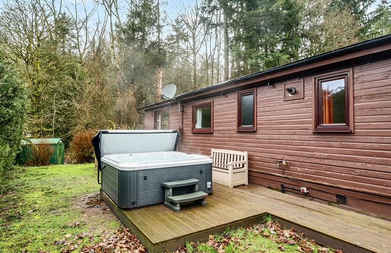 An outdoor area with a hot tub and wooden deck at Cabin 1 Moffat Manor in Beaufort