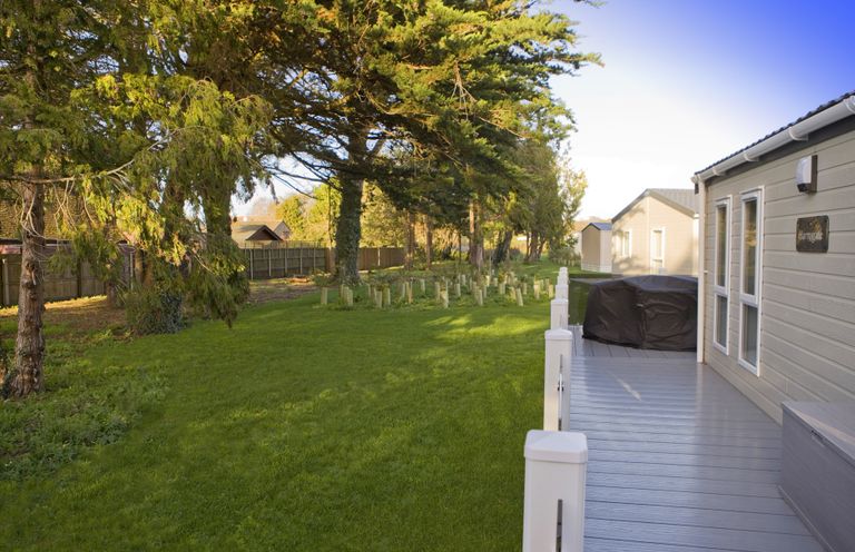 An outdoor area with a deck and grass in Orchid 9 Christchurch