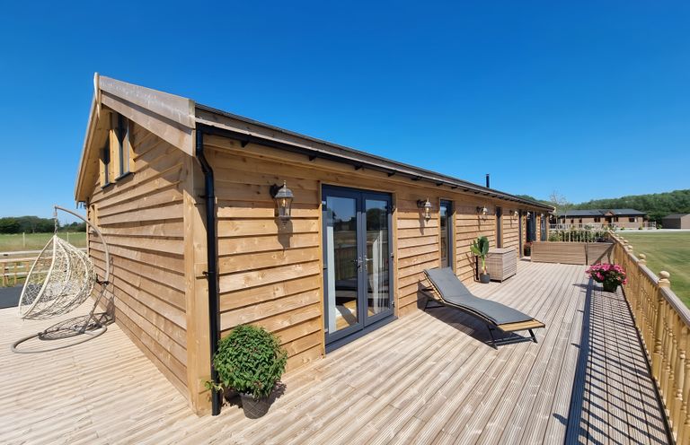 An outdoor area with a wooden cabin and seating at Fox Lodge in York