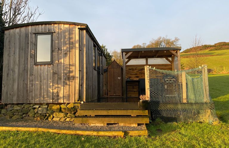 A wooden hut with a door and window at Shepherds hut Dumfries