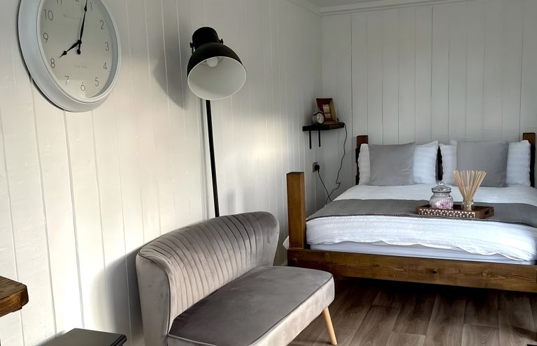 A bedroom with a bed and a seating area at Trethowels Hidden Huts in St. Austell