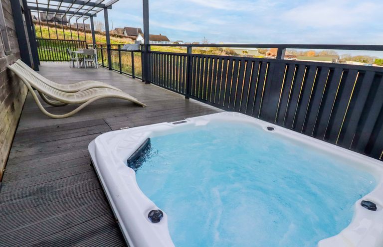 An outdoor area with a hot tub and seating at 114 - The Residance in Redruth
