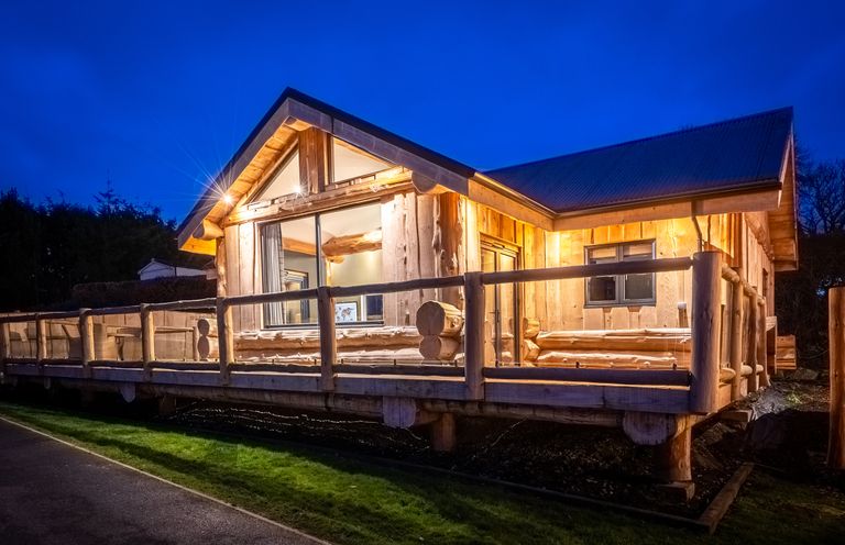 A wooden cabin with a deck and windows at Bears Den Addingham