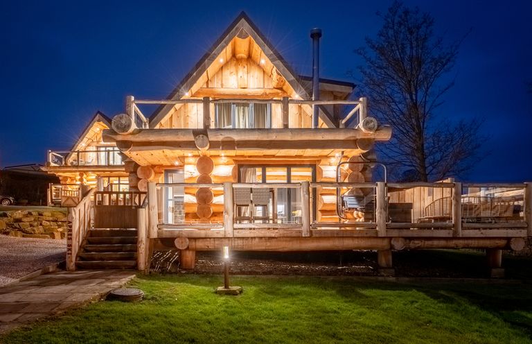 A log cabin with a deck and stairs at Apres Ski in Addingham