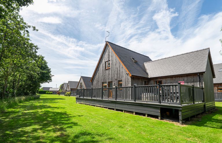A house with a deck and grass area at James Ville Marina Lodge 13 in Brigg