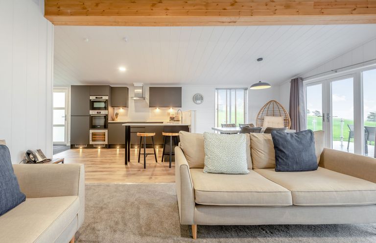A living room with a kitchen area and seating at Sonnet 2 Spa Roof Terrace (Pet) Carmarthen