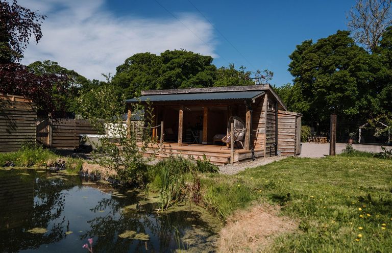 A building near a pond surrounded by trees at The Chard in Carlisle
