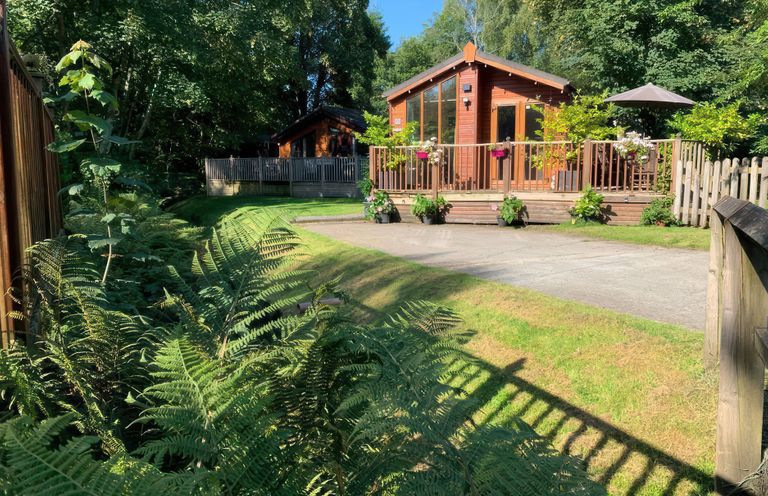 A cabin with a deck and surrounding greenery at Tiggywinkle Beck - White Cross Bay Windermere
