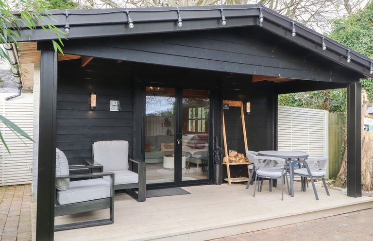 An outdoor area with seating and a table at Caban Tan Y Dderwen in Chwilog