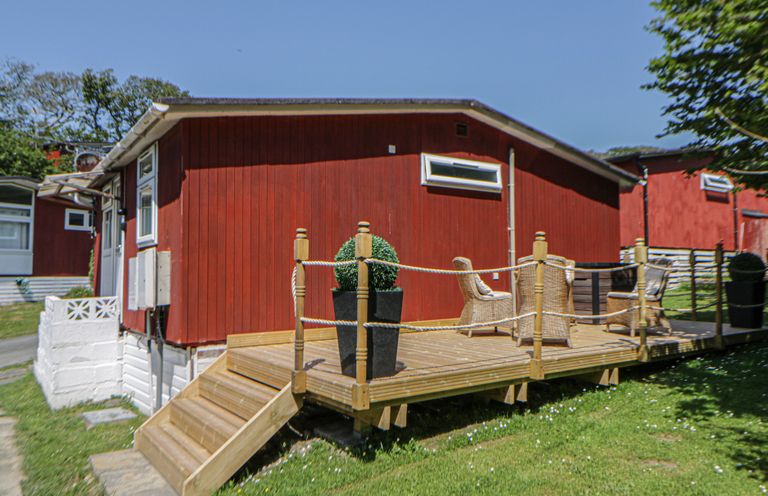 A deck with chairs and a planter at Chalet 23 Erw Porthor Tywyn